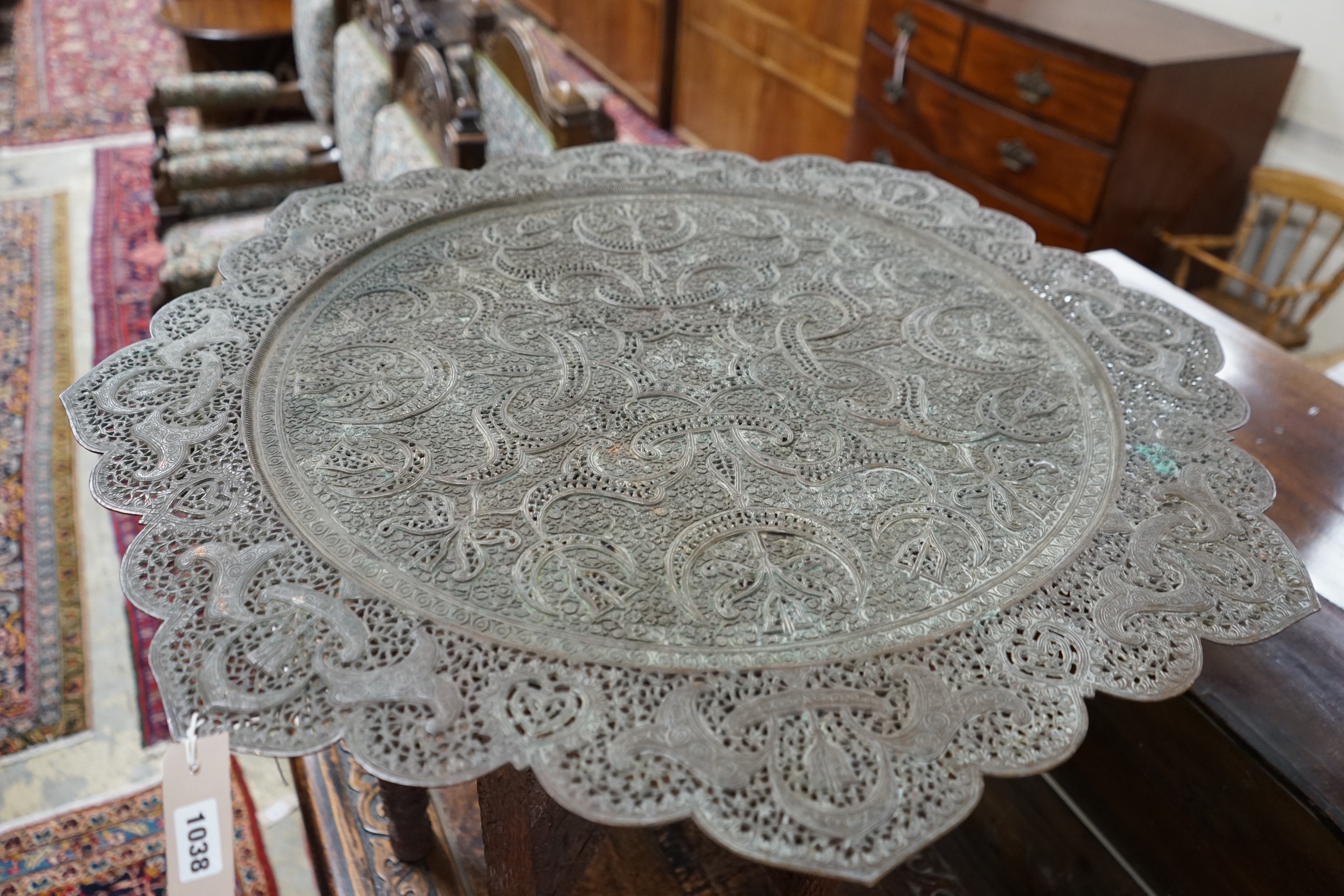 An Indian circular pierced brass tray top table, on carved folding stand, diameter 83cm, height 55cm